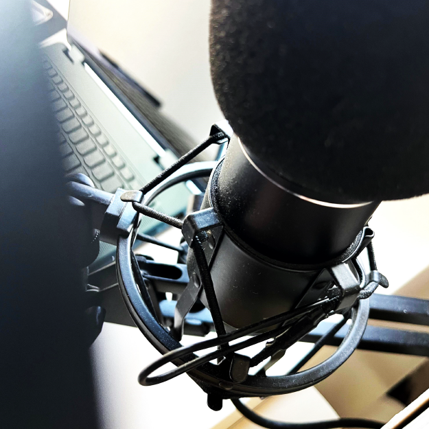 thewedesign Bild von einem Mikrofon für Audioaufnahmen und Voice-Over. Im Hintergrund ein Laptop.