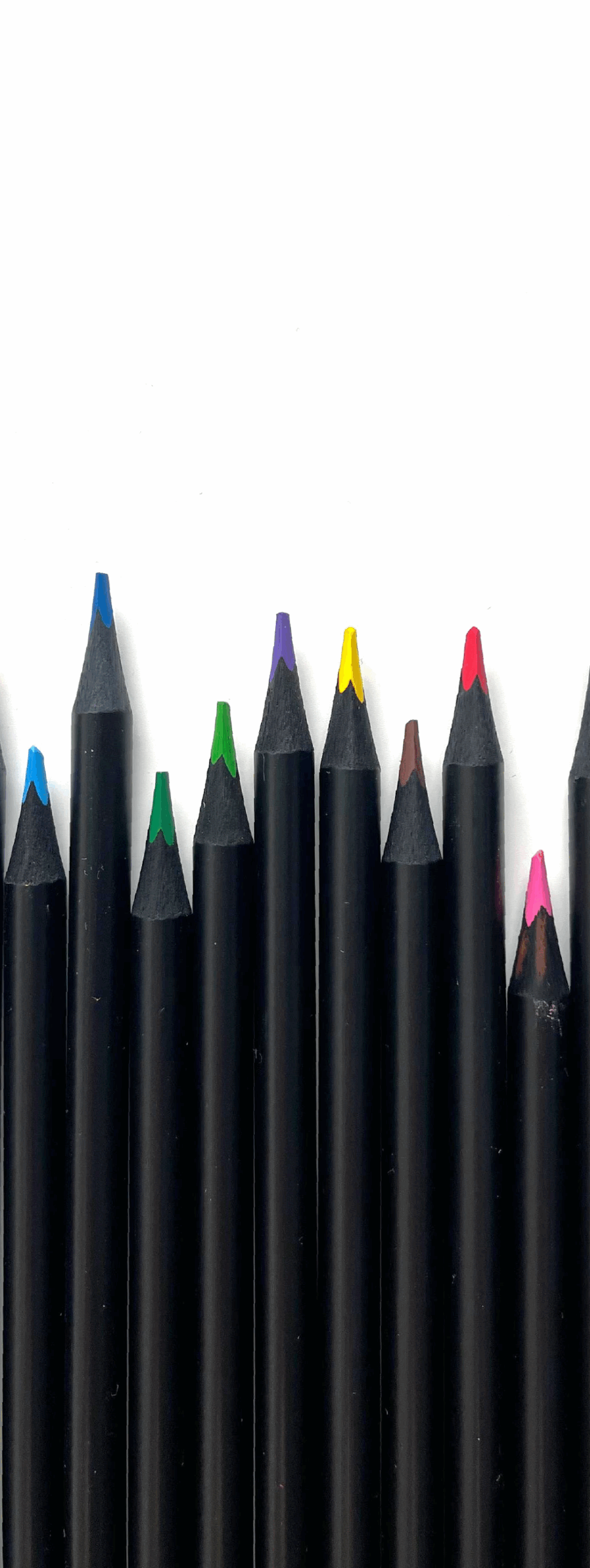 thewedesign Bild von aneinander gereihten Buntstiften mit schwarzer Umhüllung.