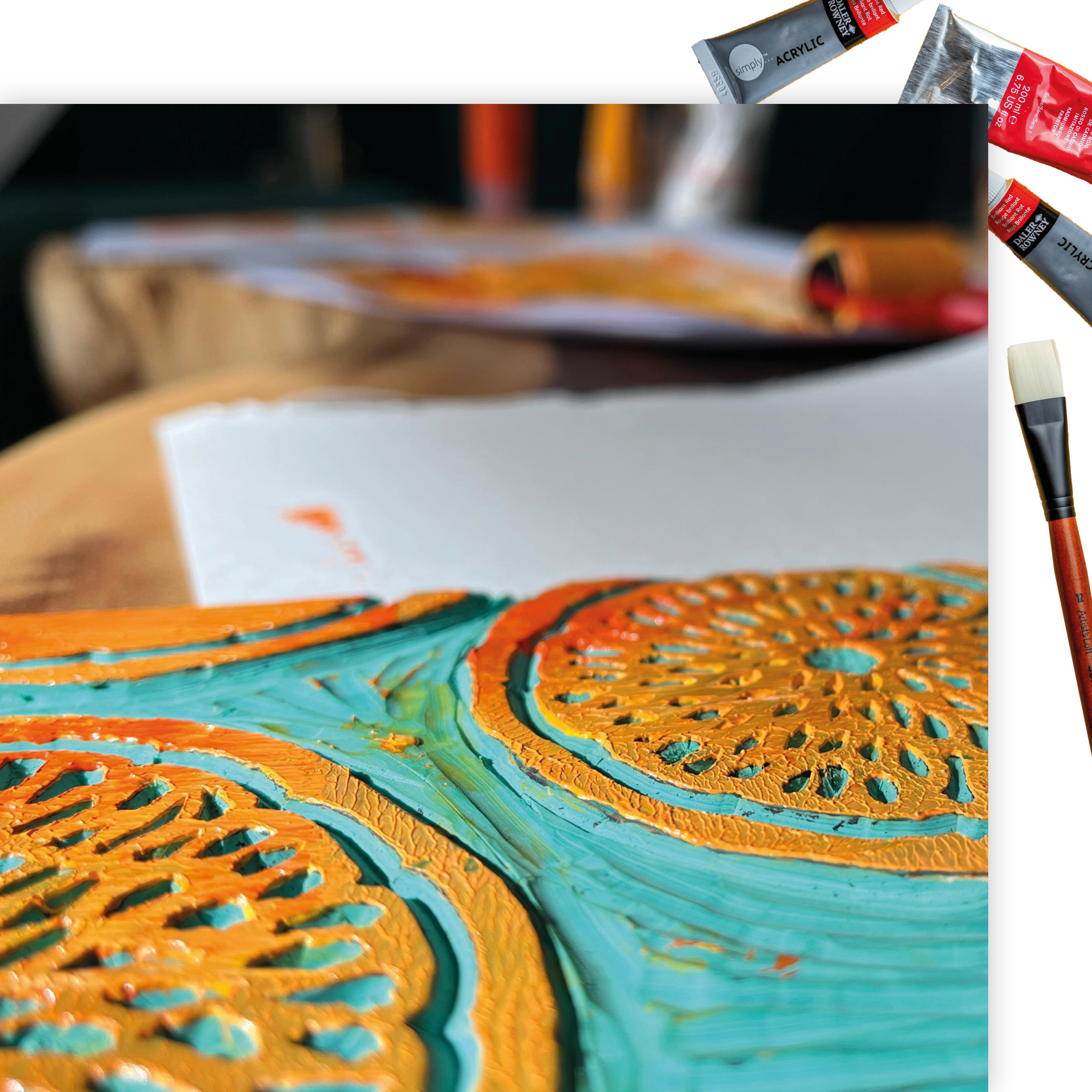 thewedesign, Art Mockup. Close-Up Bild von Linoldruck-Schnitt mit orangener Acrylfarbe, im Hintergrund die Farbrolle mit Farbe.